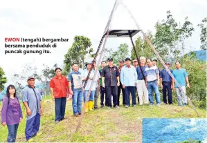  ??  ?? EWON (tengah) bergambar bersama penduduk di puncak gunung itu.