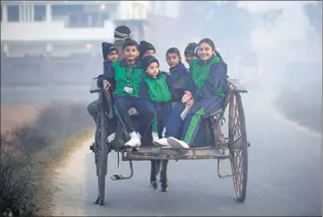  ?? PTI ?? ■ Students on their way to school on a cold Friday morning in Jammu. The city recorded a minimum temperatur­e of 7.3°Celsius.