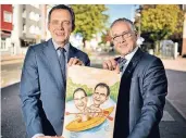  ?? RP-FOTO: RALPH MATZERATH ?? Gastgesche­nk vom polnischen Bürgermeis­ter Pawel Kalinowski (l.): eine Karikatur von der Kanutour, bei der nur Frank Schneider trocken bleib.