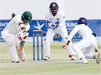  ??  ?? HARARE: Sri Lanka wicket keeper Kusal Janith Perera keeps a watchful eye as Craig Ervine plays a ball on during the fourth day of the second test match between Sri Lanka and Zimbabwe at the Harare Sports Club, yesterday. — AFP