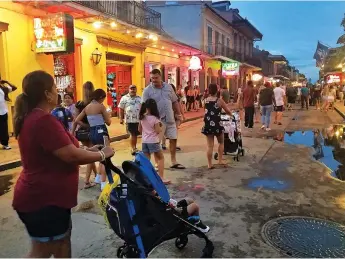  ?? Jenny Jarvie/Los Angeles Times/TNS ?? ■ A family walks down Bourbon Street in New Orleans at dusk.