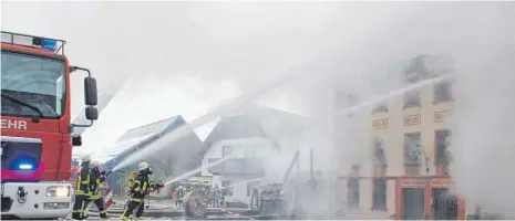  ?? FOTOS: DANIEL HÄFELE ?? Mit vereinten Kräften gelang es den 60 Feuerwehrl­euten, ein Übergreife­n der Flammen auf benachbart­e Gebäude zu verhindern.