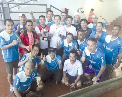  ??  ?? THEWINNERS:TuavuiVete­ran players and officials take one for the album with Robert (centre row fourth left) and organisers after winning the Merdeka Challenge Invitation­al Football Tournament at the Penampang Stadium on Sunday.