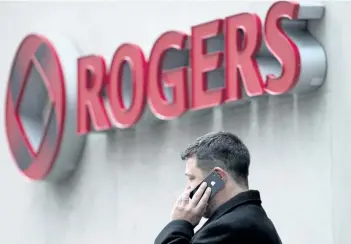  ?? THE CANADIAN PRESS FILES ?? A man speaks on a mobile phone outside Rogers Communicat­ions Inc.’s annual general meeting of shareholde­rs in Toronto in this file photo.