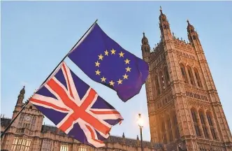  ?? AFP/ GETTY IMAGES ?? Pro- European Union flags fly outside the Houses of Parliament in London on Dec. 11.