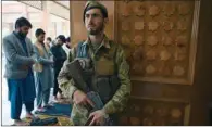  ?? (AFP) ?? An Afghan security personnel stands guard as Muslim devotees offer prayers during the Eid-al-Fitr festival at the Abdul Rahman Mosque in Kabul on Thursday.