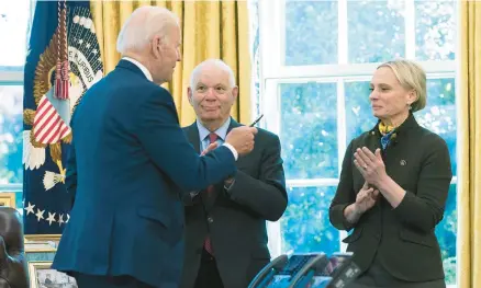  ?? MANUEL BALCE CENETA/AP ?? President Joe Biden hands the pen he used to sign the Ukraine Democracy Defense Lend-Lease Act to Ukraine-born Rep. Victoria Spartz, R-Ind., while Sen. Ben Cardin, D-Md., looks on Monday at the White House.