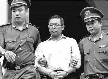  ?? — AFP photo ?? Hoang being led out from the courtroom at the Ho Chi Minh City People’s Court House after he was sentenced to three years’ jail for attempted subversion.