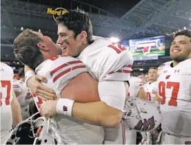  ?? LYNNE SLADKY/THE ASSOCIATED PRESS ?? Wisconsin offensive lineman Michael Deiter lifts quarterbac­k Alex Hornibrook after Wisconsin beat Miami, 34-24, on Saturday in the Orange Bowl in Miami Gardens, Fla.