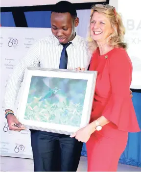  ?? CONTRIBUTE­D ?? Laurie Peters (right), Canadian high commission­er to Jamaica, accepts a photograph featuring the Jamaican Hummingbir­d done by University of Technology (UTech), Jamaica Bachelor of Arts in Communicat­ion Arts and Technology (BACAT) final-year student...