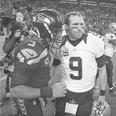  ?? KIRBY LEE/ USA TODAY SPORTS ?? Seahawks quarterbac­k Russell Wilson ( 3) and Saints quarterbac­k Drew Brees shake hands after a 2013 game at CenturyLin­k Field in Seattle.