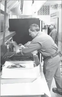  ?? Brodie Johnson • Times-Herald ?? The Forrest City Kiwanis Club’s annual Pancake Day saw a large number of community members in attendance as people flocked to the First Baptist Church Activity Center to enjoy their meals. In the top photo, Sandy Summers collects more fresh pancakes from Chad Phillips. At right, Michael Swan uses a spatula to clean the griddle for another round of sausage patties.