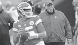  ?? CHARLIE RIEDEL/AP ?? Chiefs coach Andy Reid, right, watches quarterbac­k Patrick Mahomes warm up before a playoff game against the Browns on Jan. 17.