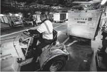  ??  ?? Baggage employees work to move luggage to aircraft at Bush. A new system will boost capacity to about 77,000 bags a day.