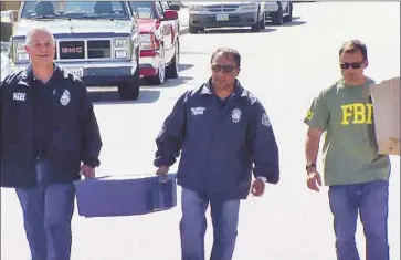  ?? FBI ?? FBI AGENTS HOLD a bin of cash excavated Wednesday from the Fontana backyard of Cesar Yanez, a former armored-truck driver convicted of stealing $1 million from a bank vault. Officials recovered $600,000.
