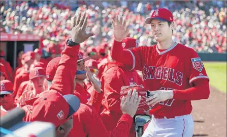  ?? Robert Gauthier Los Angeles Times ?? SHOHEI OHTANI IS GREETED with enthusiasm by Angels teammates after his U.S. debut. “Besides the results, I had a lot of fun out there,” he said. Ohtani said he got cold between innings, when he couldn’t throw in front of the dugout, as is allowed in...