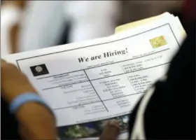  ?? LYNNE SLADKY — THE ASSOCIATED PRESS ?? A job applicant looks at job listings for the Riverside Hotel at a job fair hosted by Job News South Florida, in Sunrise, Fla.