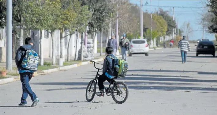  ?? FOTOS: JUAN JOSÉ GARCÍA ?? Calles mansas. Dos niños por el centro de Ausonia, al salir de la escuela. Casi todos en el pueblo cordobés viven de la actividad agropecuar­ia.