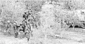  ??  ?? Israeli soldiers walk near the site of an Israeli excavation site for reported Hezbollah-dug tunnels along the Lebanon-Israel border. — AFP photo