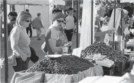  ??  ?? Dos mujeres observan unas castañas en uno de los puestos.