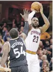  ??  ?? Cavaliers forward LeBron James shoots over Raptors forward Patrick Patterson during the second half on Monday.