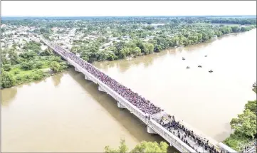  ?? — AFP photos ?? Aerial view of a Honduran migrant caravan heading to the US, as it is stopped at a border barrier on the Guatemala-Mexico internatio­nal bridge in Ciudad Hidalgo, Chiapas state, Mexico.