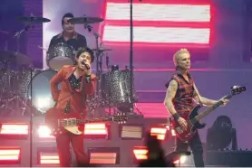  ?? AP PHOTO/CHRIS PIZZELLO ?? Billie Joe Armstrong, left, Mike Dirnt, right, and Tre’ Cool, top left, of the band Green Day perform on day three of the Bud Light Super Bowl Music Fest in 2022 at Crypto.com Arena in Los Angeles.