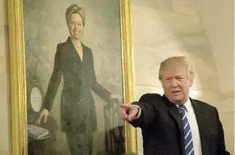  ??  ?? Casa Bianca Donald Trump, 70 anni, saluta un gruppo di visitatori. Alle sue spalle, un ritratto dell’ex first lady Hillary Clinton (Getty)