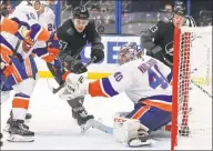  ?? Mike Carlson / Associated Press ?? New York Islanders goaltender Semyon Varlamov and the Lightning’s Mitchell Stephens look for a loose rebound during the second period on Saturday.