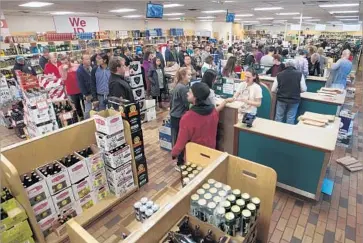  ?? Steve Griffin Salt Lake Tribune ?? PATRONS FORM lines at Sugar House liquor store in Salt Lake City. Calls and emails flooded the Utah governor’s office over the drunk driving standard, which lowers the legal blood alcohol level from 0.08% to 0.05%.