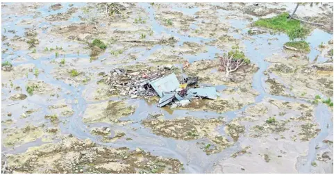  ?? — AFP ?? Nothing else left: The roof of a house remains after devastatio­n from soil liquefacti­on at Petobo near Palu.