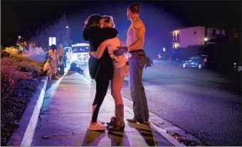  ?? Michael Owen Baker For The Times ?? PEOPLE EMBRACE after the deadly Borderline Bar & Grill shooting in Thousand Oaks in 2018. A dip in confidence in gun laws is a response to what people are seeing in their communitie­s, a pollster says.