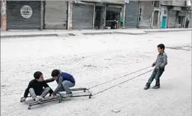  ?? Joseph Eid AFP/Getty Images ?? CHILDREN play in Aleppo. About 1.75 million youths in Syria are out of school and most are up to six years behind in their reading and math skills, a report says.