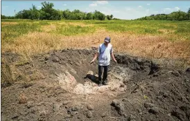  ?? EFREM LUKATSKY / AP ?? Serhiy Hrebtsov, a grain producer, shows a crater left by a Russian shell on his field in the eastern Donetsk region, Ukraine, on June 12. “There are some options to sell (at very low prices), but it is like just throwing it away,” he said.