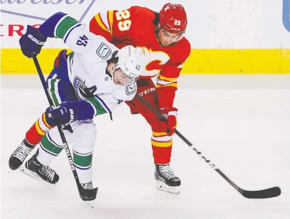  ?? — GETTY IMAGES FILES ?? Quinn Hughes fights to get the inside track on Dillon Dube of the Flames as they pursue the puck during NHL action last week in Calgary. Through three games, Hughes leads the Canucks with three points, 11 shots and an average of 24:27 per contest in ice time.