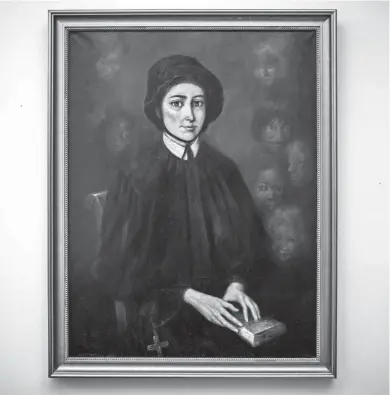  ?? JOHN MINCHILLO/AP ?? A portrait of Saint Elizabeth Ann Seton, the founder of the first American congregati­on of the Sisters of Charity, hangs in the meeting room of La Gras Hall where the leadership council of the order convenes at the College of Mount Saint Vincent, a private Catholic college in the Bronx borough of New York.