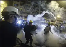  ?? ERIC TSANG — HK01VIA AP ?? ABOVE: Hong Kong police launch tear gas at protesters Sunday after a massive pro-democracy march continued into the evening.