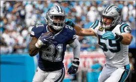  ?? STREETER LECKA / GETTY IMAGES ?? Ezekiel Elliott seeks to outrun Panthers linebacker Luke Kuechly in Sunday’s game. Elliott rushed for 69 yards and a touchdown as the Cowboys fell 16-8 in Charlotte, North Carolina.