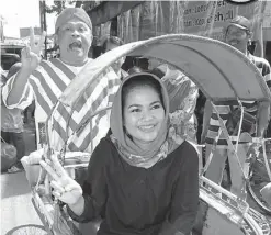  ?? TIM PEMENANGAN­AN GUS IPUL-PUTI FOR JAWA POS ?? VOTE GETTER: Puti naik becak yang dikayuh oleh pelawak Kirun di Bojonegoro.