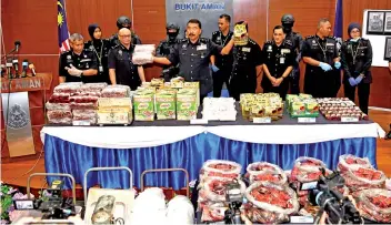  ?? – Bernama photo ?? Ramli holds up two packages of drugs from the estimated RM10 million-haul resulting from Op Nutcracker, during the press conference in Bukit Aman.