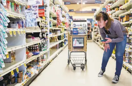  ?? Photos by Jessica Christian / The Chronicle ?? Grocery delivery shopper Courtney Fox of Newark searches for items for three Instacart orders at Safeway in Palo Alto.