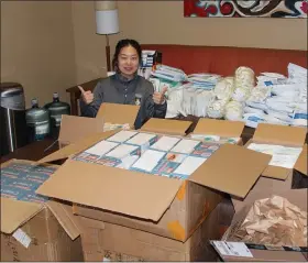  ?? SUBMITTED PHOTOS ?? Yijuan Qiu, Hill’s administra­tive coordinato­r and internatio­nal family liaison, with a large shipment of masks received recently for local distributi­on.