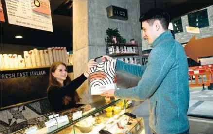  ?? AFP ?? A Karma app user collects his food, ordered through the food-sharing app, from a Coco Di Mama food outlet in London.