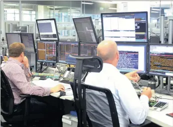  ?? PHOTO: SIMPHIWE MBOKAZI ?? Traders in the Standard Bank trading room yesterday when the rand touched R14 against the dollar.