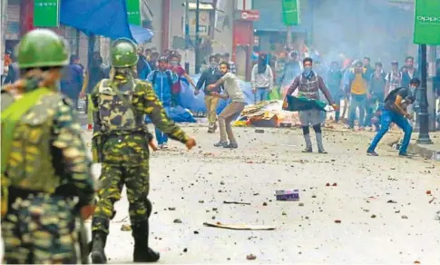  ?? WASEEM ANDRABI/HT PHOTOS ?? CRPF men and civilians during clashes in the vicinity of Lal Chowk in Srinagar on Monday.