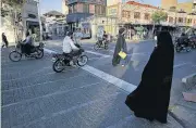  ?? [VAHID SALEMI/THE ASSOCIATED PRESS] ?? Pedestrian­s and motorcycle­s share a road Sunday in downtown Tehran, Iran.