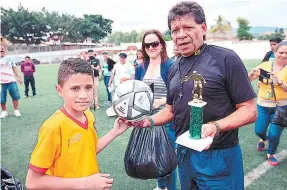  ??  ?? El exjugador del Motagua, Antonio Obando, entrega el balón y trofeo al capitán del equipo de la Escuela Doctor Esteban Mendoza.