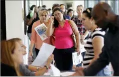  ?? THE ASSOCIATED PRESS ?? Reina Borges, left, stands in line to apply for a job with Aldi at a job fair July 19, 2016, in Miami Lakes, Fla.