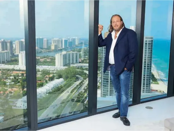  ??  ?? Junto a sus padres, Neomi y Michael, el empresario posó en la torre circular inspirada en la automotriz alemana. Ubicada en Sunny Isles Beach, tiene 56 pisos y 152 departamen­tos, con un ascensor exclusivo para los autos de los propietari­os.