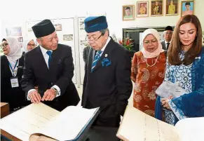  ??  ?? Just in case: Arifin (left) showing Sultan Sharafuddi­n Idris Shah record books of old court cases after the opening of the new Klang Court Complex. Looking on are Tengku Permaisuri Norashikin (right) and the Chief Justice’s wife Toh Puan Robiah Abd...